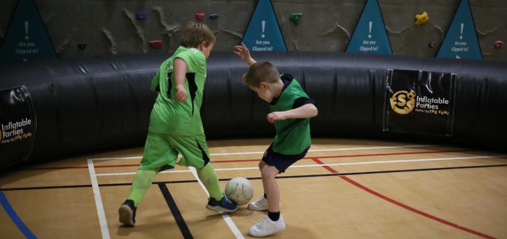 Two children playing football inside the FSS inflatable pitch